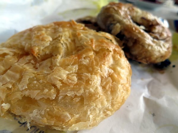 Photo of two flakey, round pastries served on paper sheet